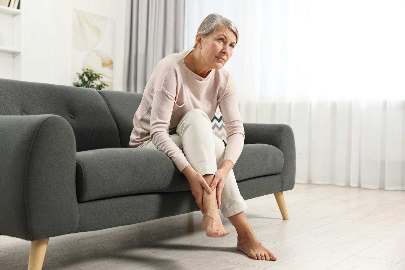 Woman holding sore ankle