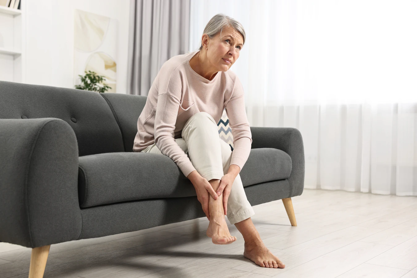 Woman holding sore ankle