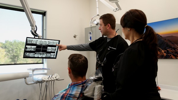 Dr. Krendl, hygienist, and patient looking at x-rays
