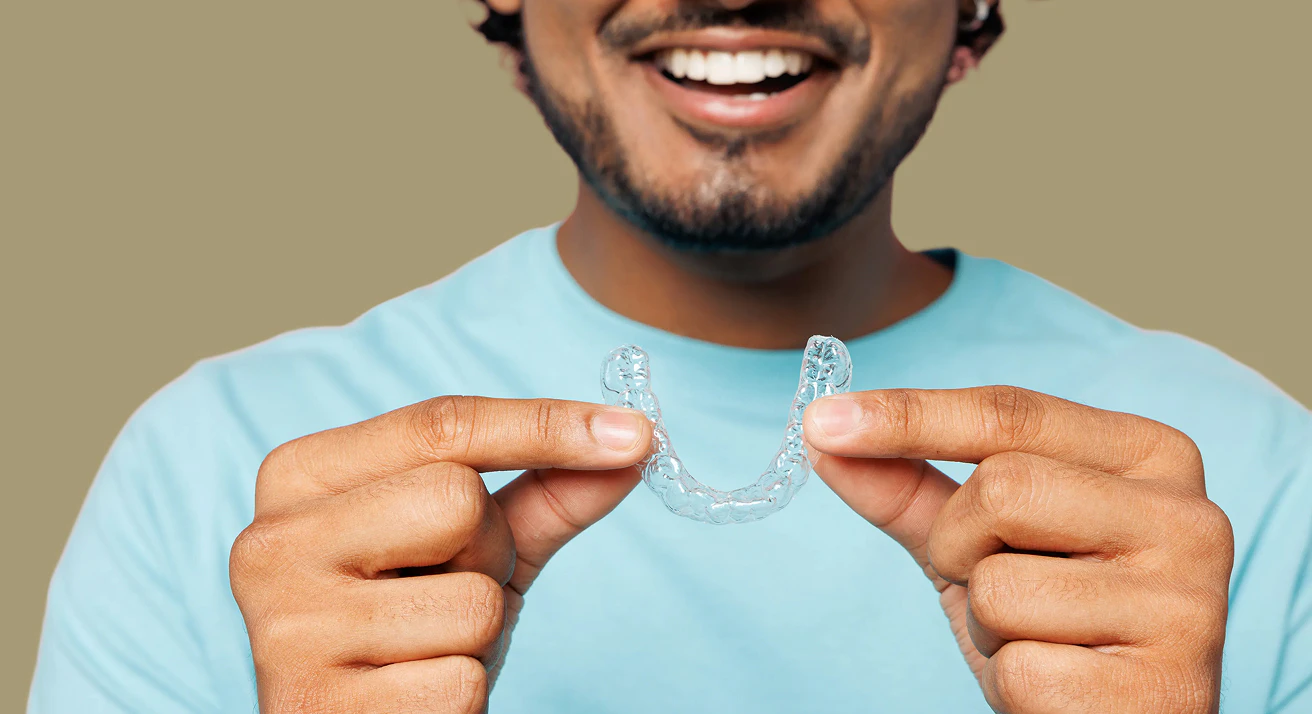 man holding invisalign aligner