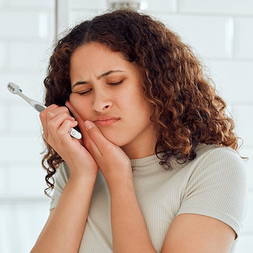 Girl holding cheek in pain