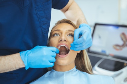 female patient having her teeth examined by dentist