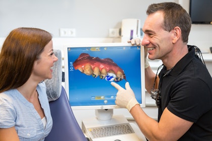 Dentist and patient looking at a digital scan made by CEREC machine