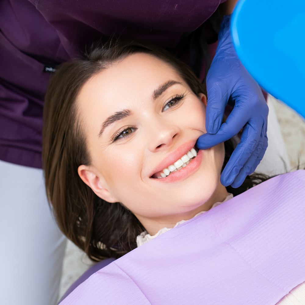 Woman smiling in the mirror at the dentist