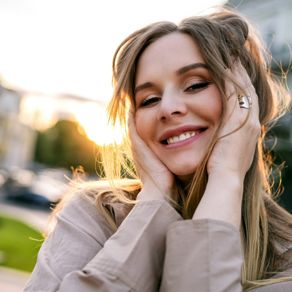 woman smiling with head in her hands