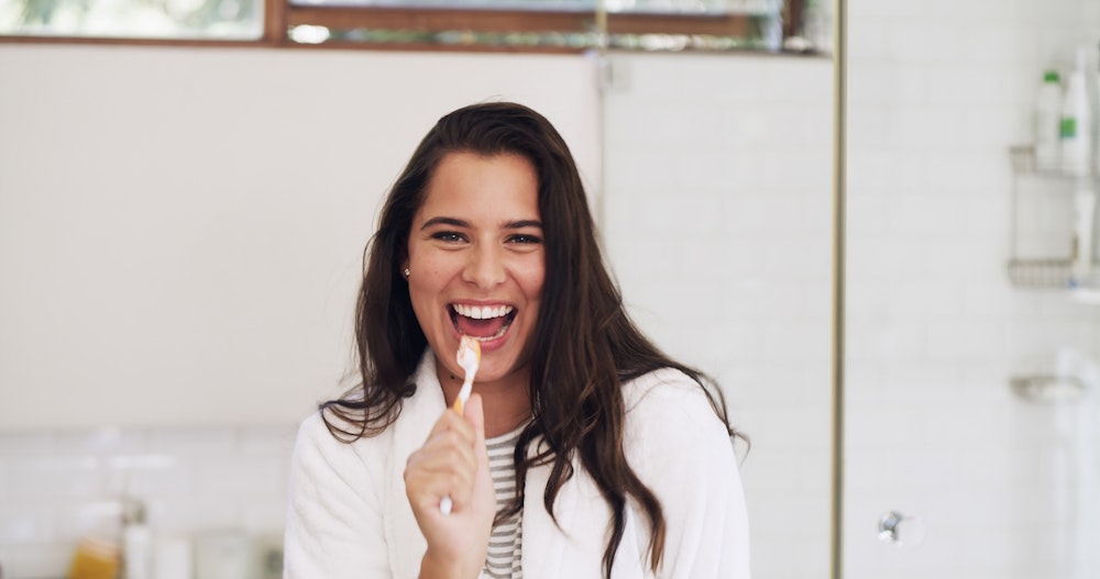 Woman smiling holding a toothbrush