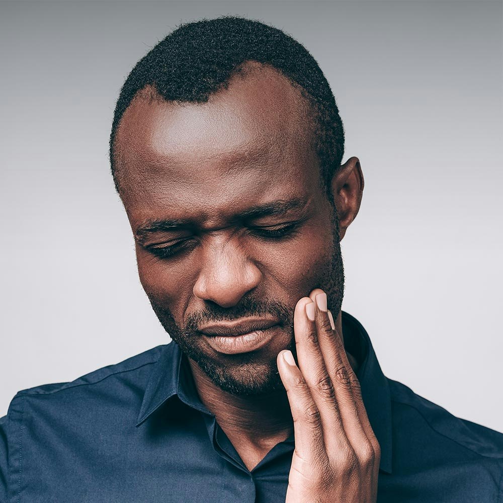 man holding jaw in pain