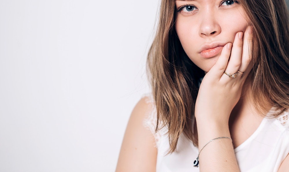 Woman holding jaw in pain