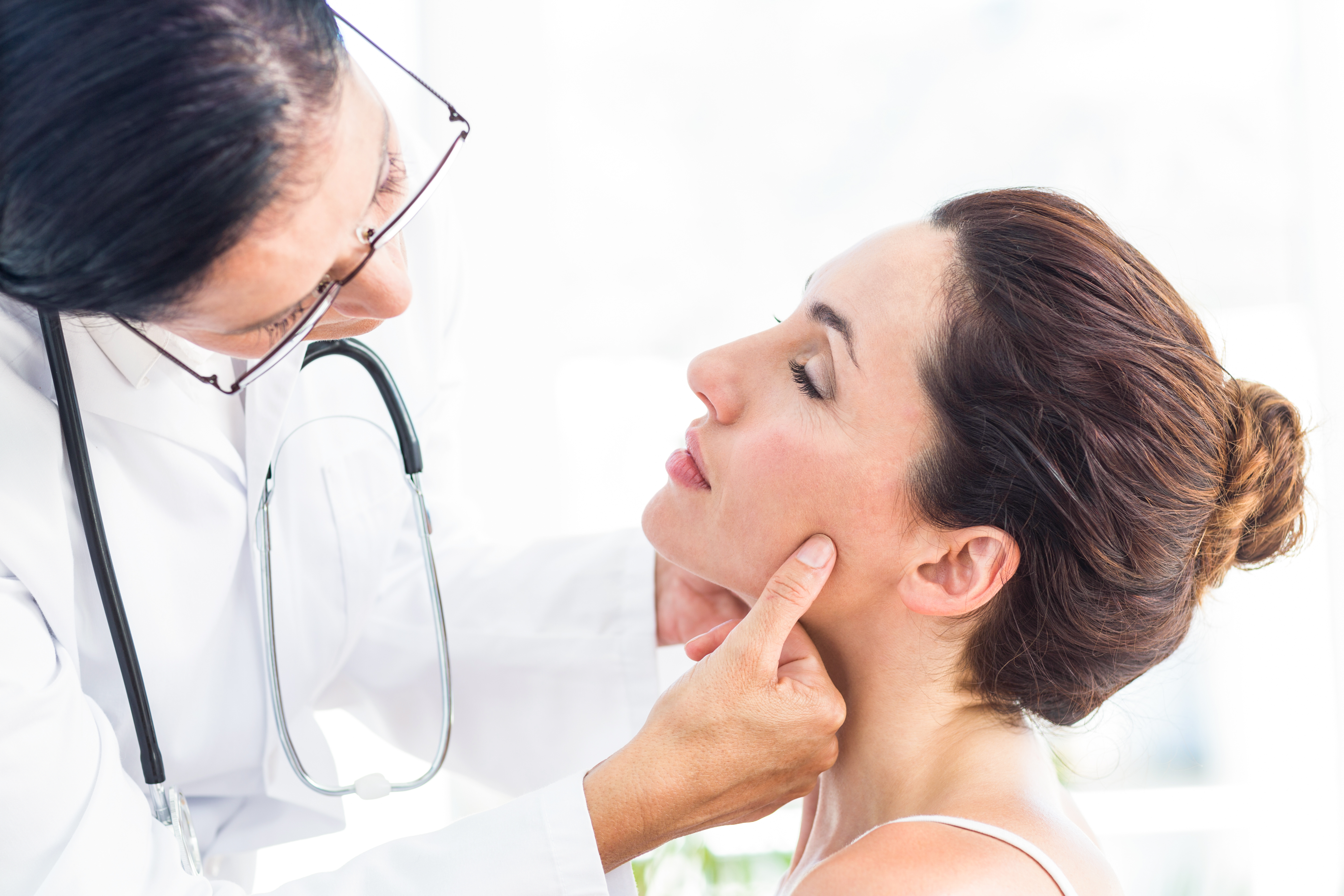 doctor examining woman's face