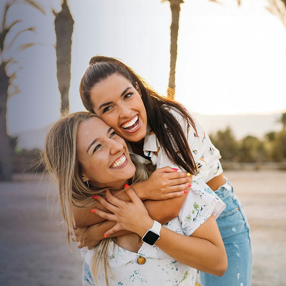 friends laughing and hugging on the beach