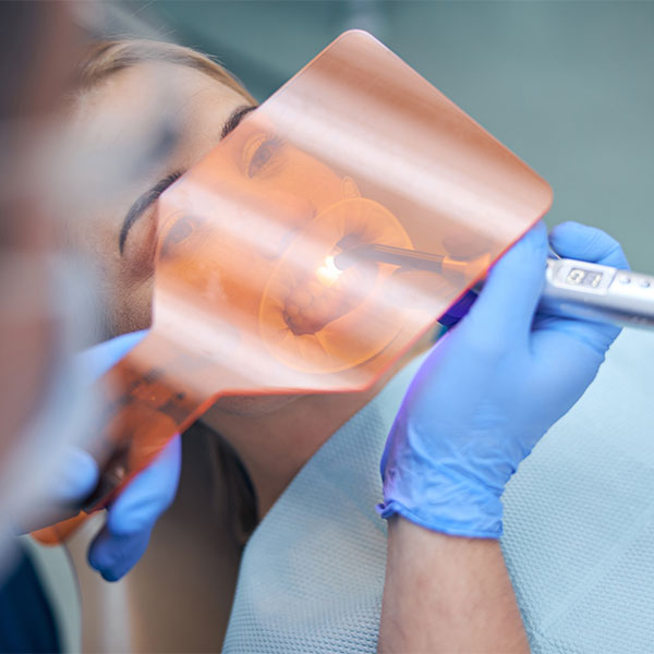 Dentist working with bonding agent on patient