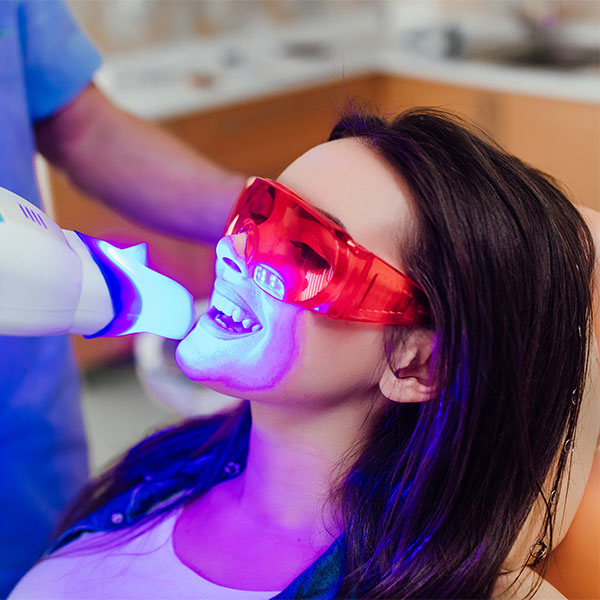 Woman getting her teeth professionally whitened at the dentist