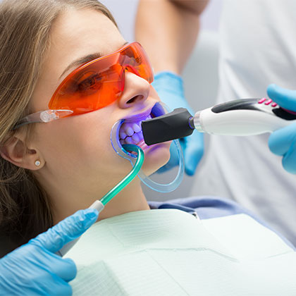 Woman getting her teeth professionally whitened at the dentist