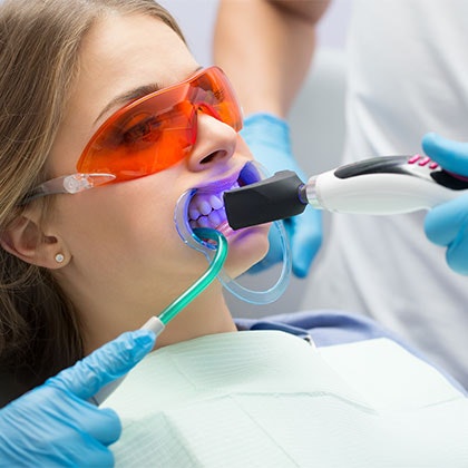 Woman getting her teeth professionally whitened at the dentist