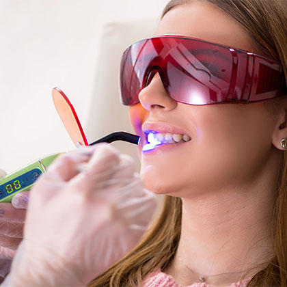 Dentist using bonding tool on patient