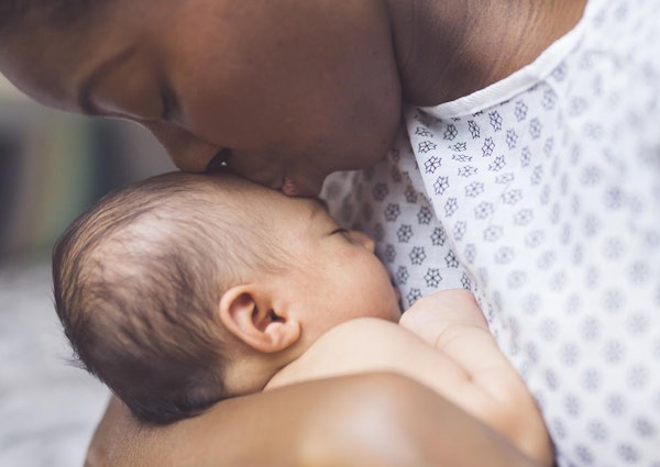 Mother kissing baby's forehead