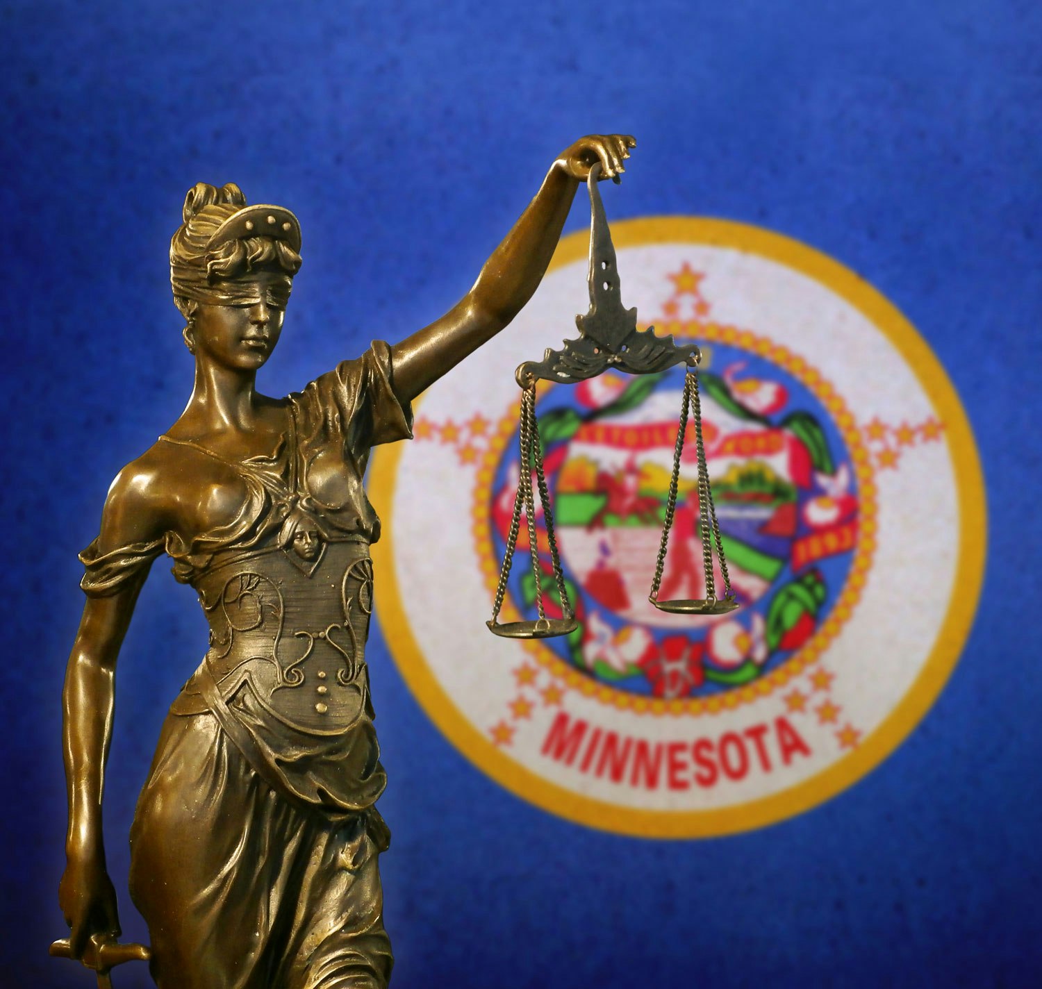 Lady Justice against Minnesota state flag