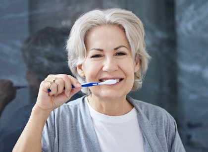mature woman brushing teeth
