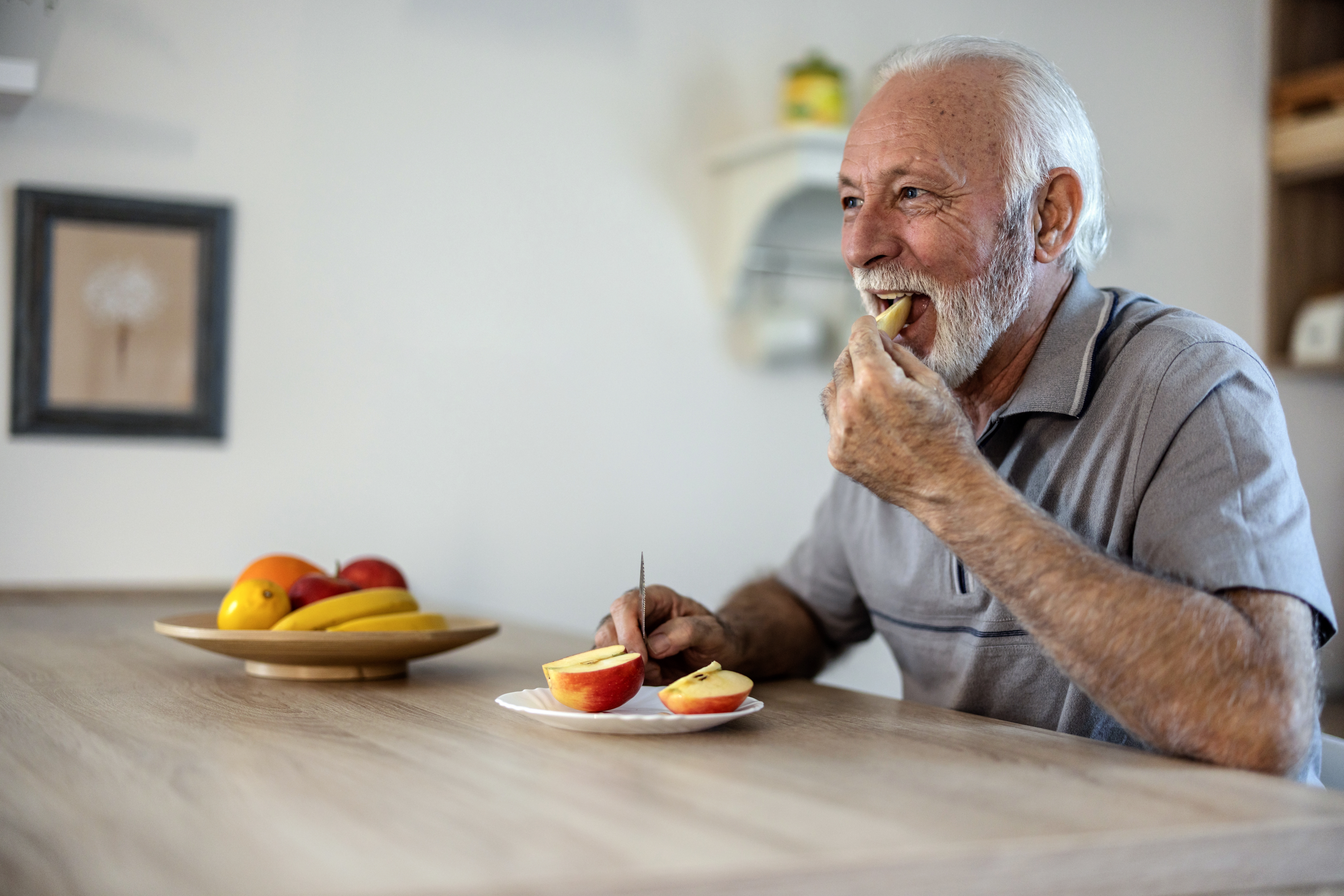 mature man eating sliced apple