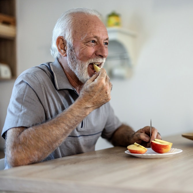 mature man eating sliced apple