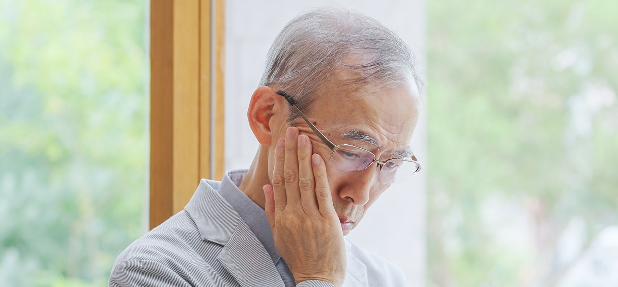 Man holding jaw in pain