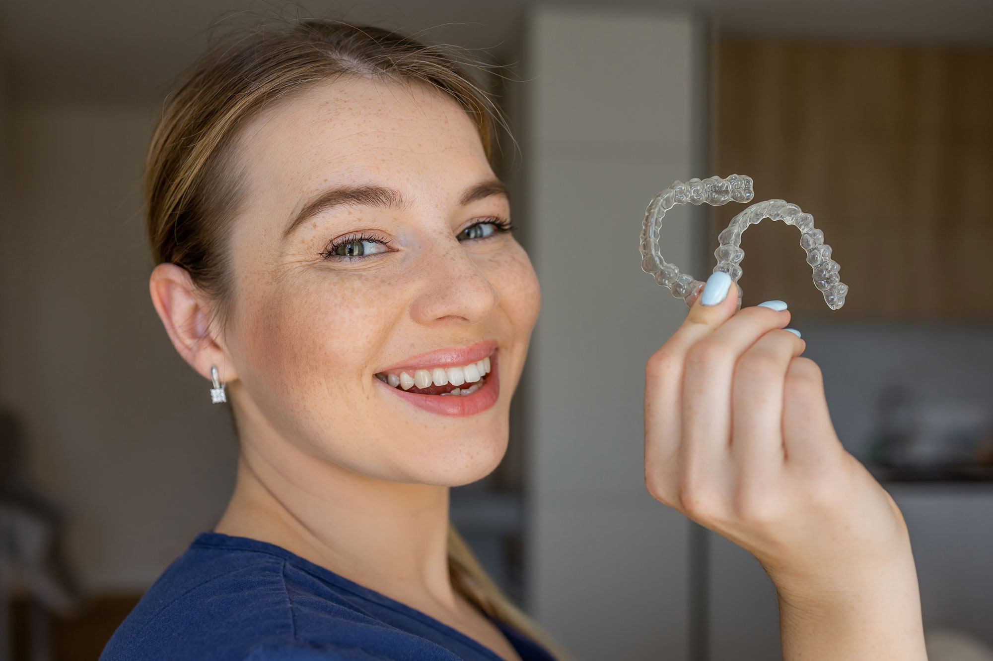 woman holding clear aligners