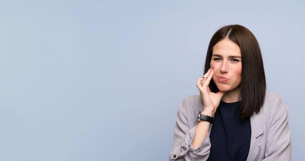 woman hold jaw in pain