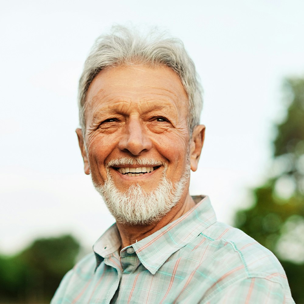 Smiling man after getting dental bridges
