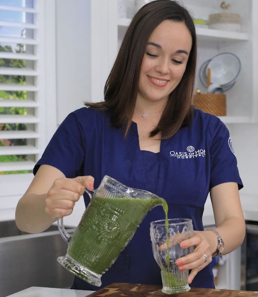 Oasis Breast Cancer Center worker pouring out a detox drink