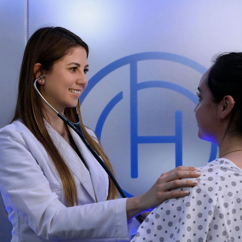 Oasis Breast Cancer Center worker pouring out a detox drink