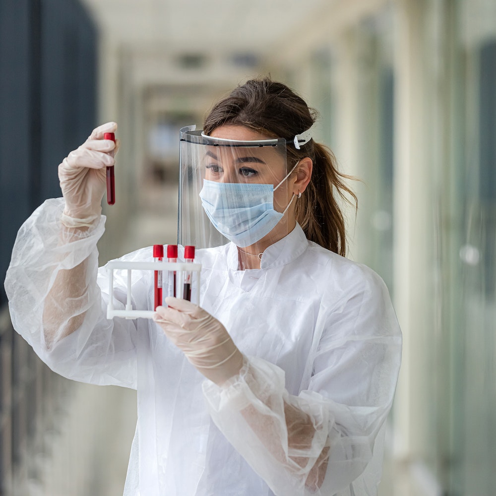 Woman holding blood in vials for Dendritic Cell Vaccine (DCV)