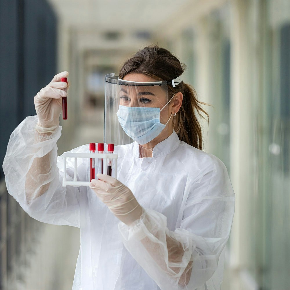 Woman holding blood in vials for Dendritic Cell Vaccine (DCV)