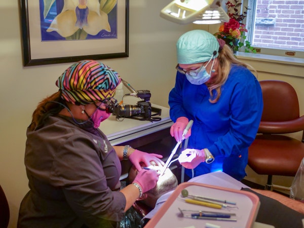Dentist and dental hygienist cleaning teeth