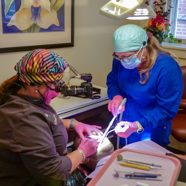 Dentist and dental hygienist cleaning teeth