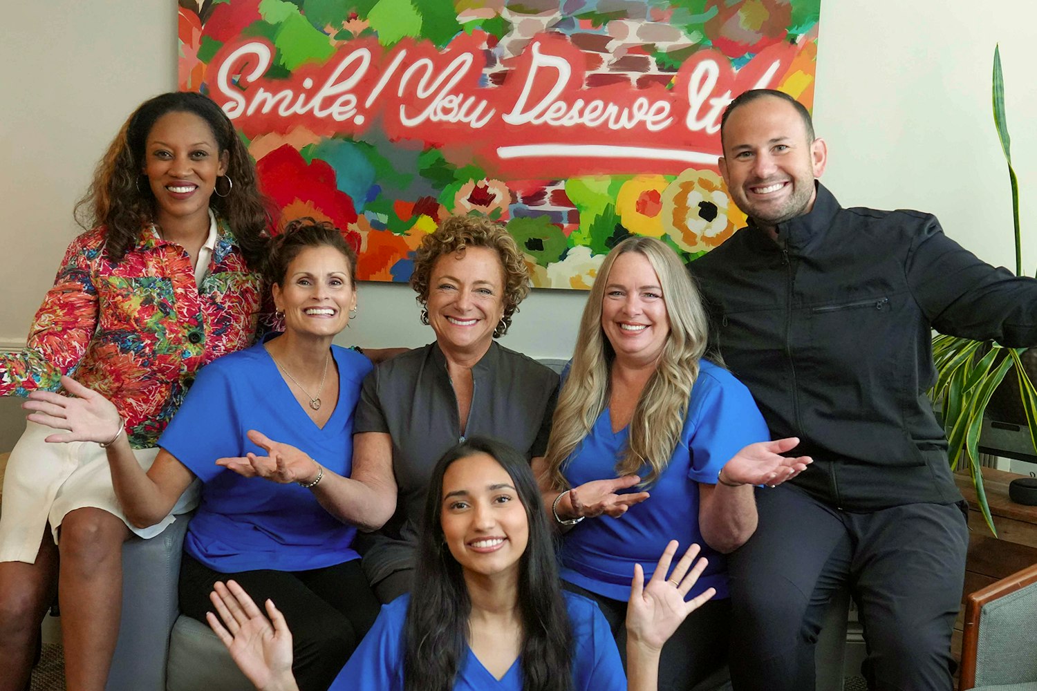 Center for Esthetic Dentistry team members in scrubs smiling and waving