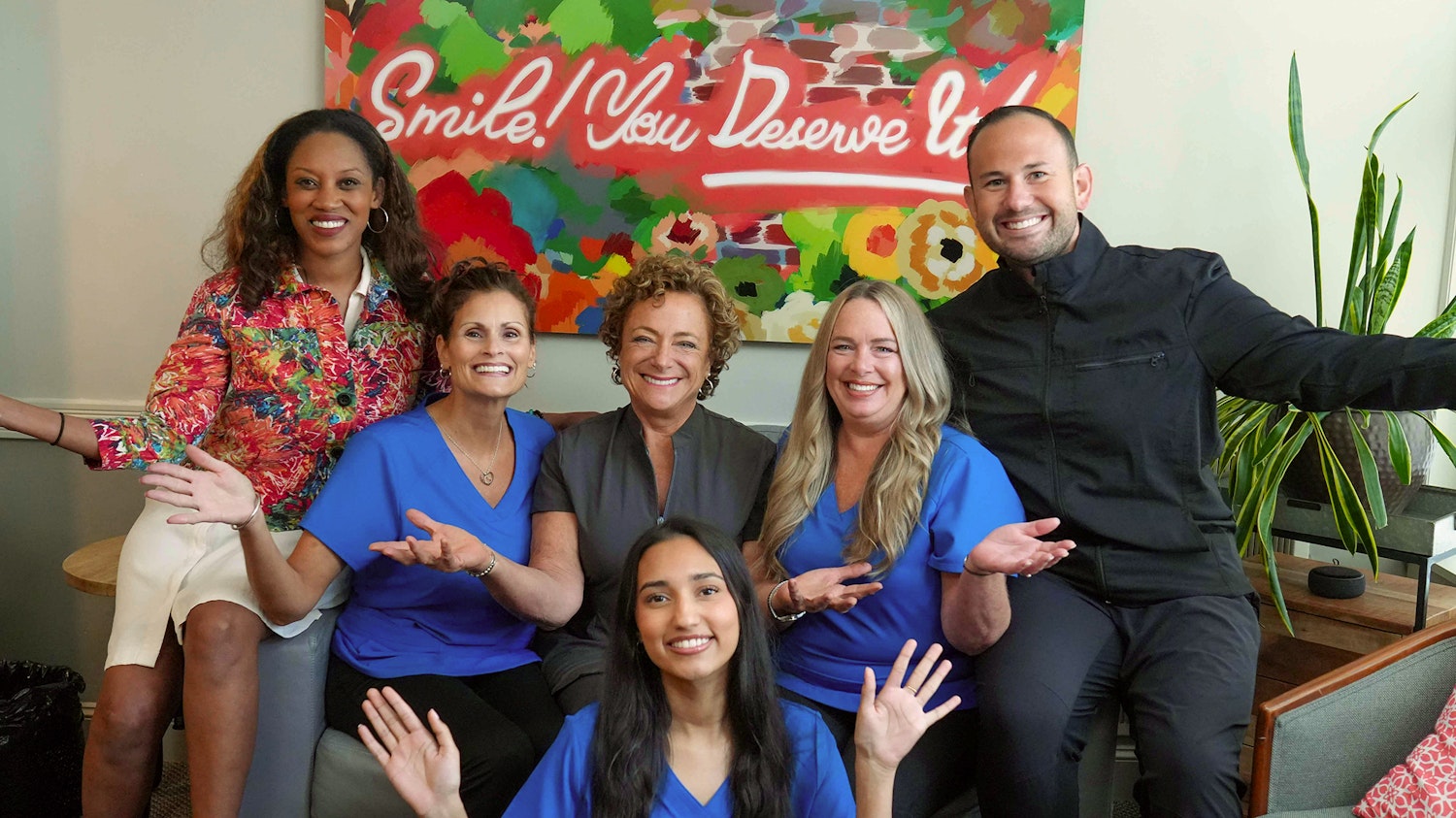 Center for Esthetic Dentistry team members in scrubs smiling and waving