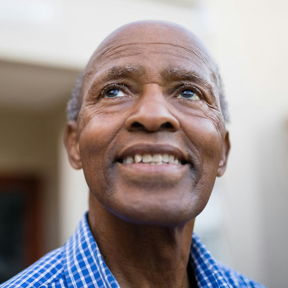 Man with well-managed glaucoma smiling and looking up