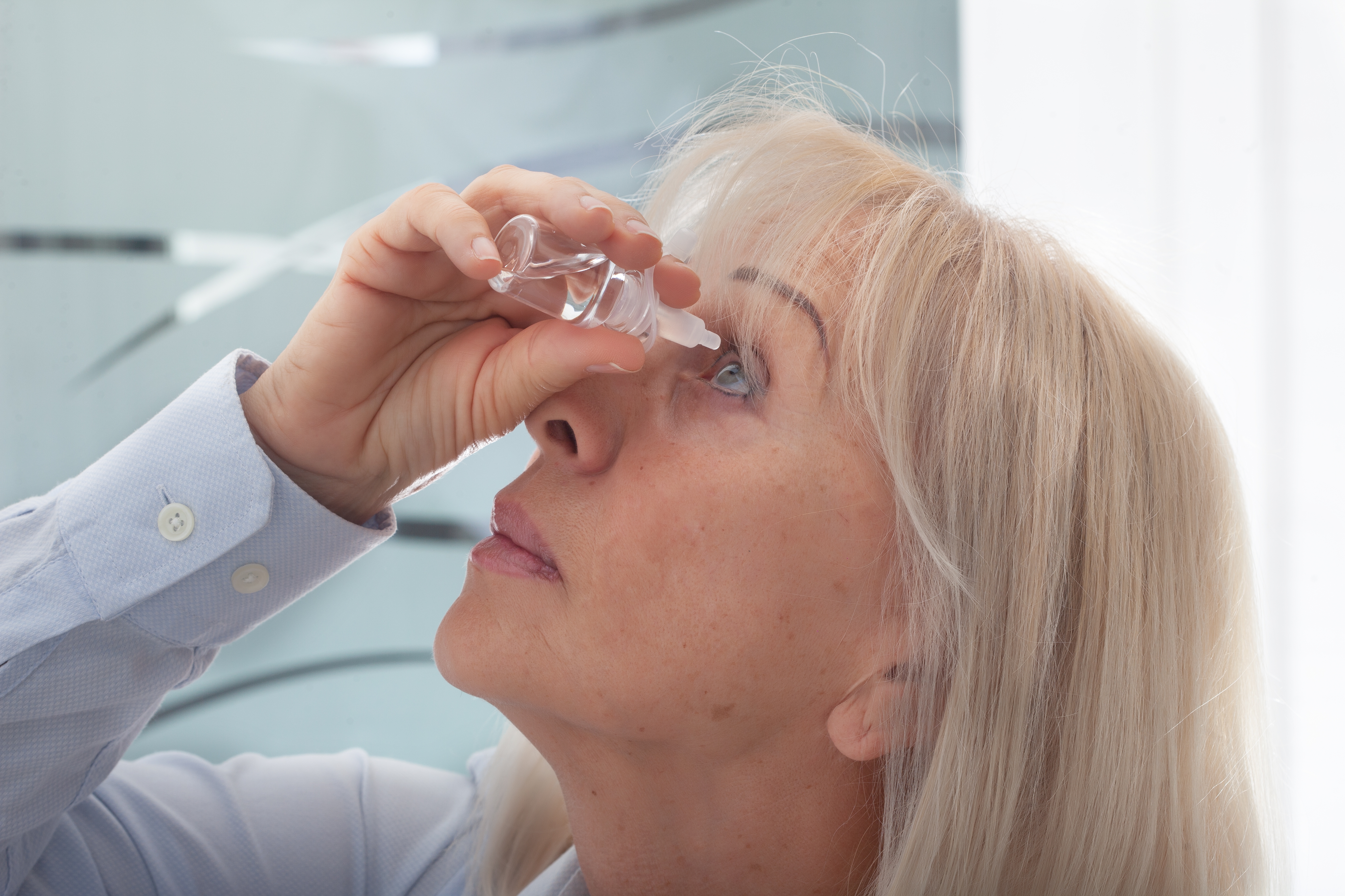 woman using eye drops