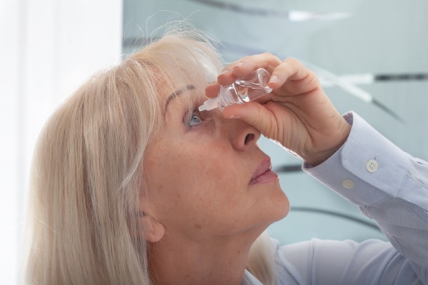 woman using eye drops