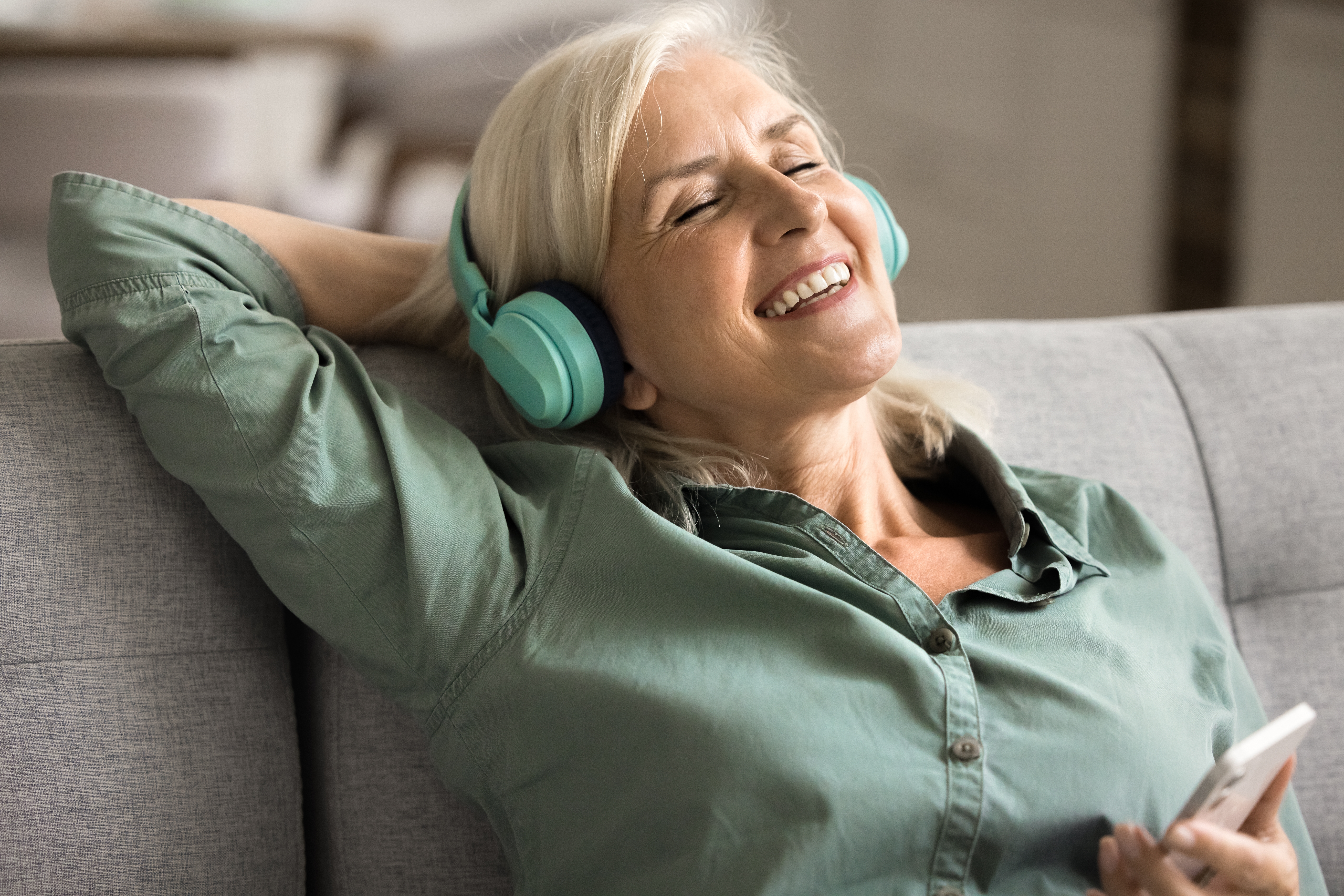woman relaxing on her couch while listening to music