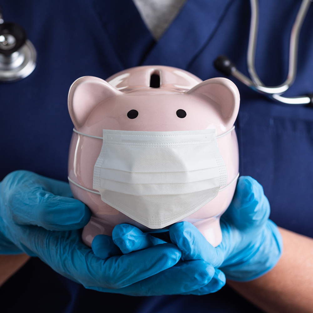 a medical worker holding a piggy bank