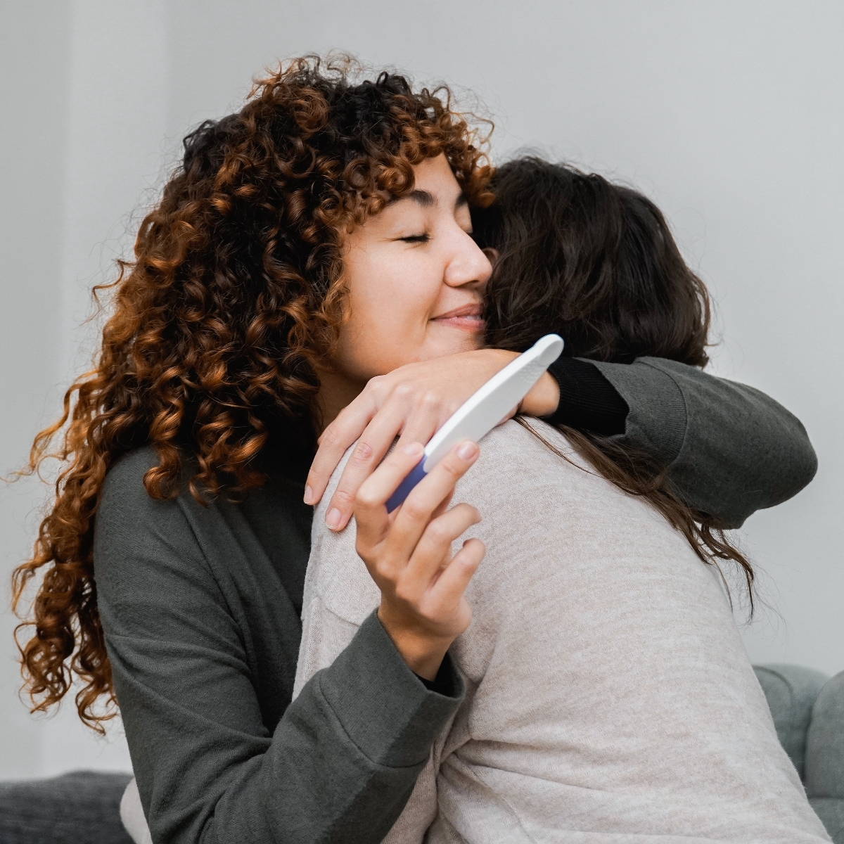 Same sex female couple hugging with pregnancy text