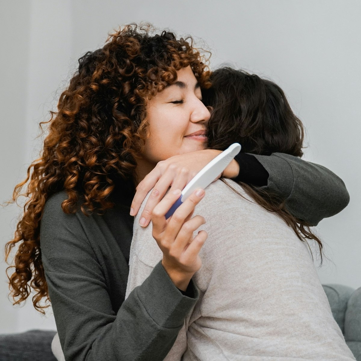 Same sex female couple hugging with pregnancy text