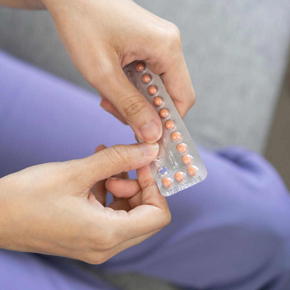 Woman popping out pill from a pill pack