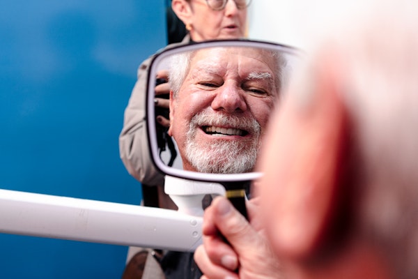 man examining teeth after cleaning