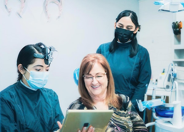 dentist and patient reviewing treatment options on tablet