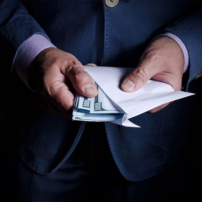 Person holding an envelope full of cash