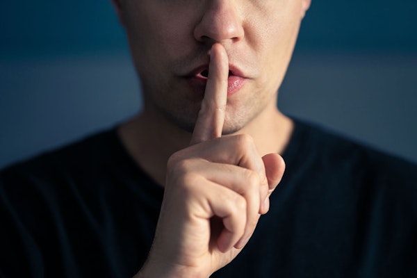 Man holding finger to lips