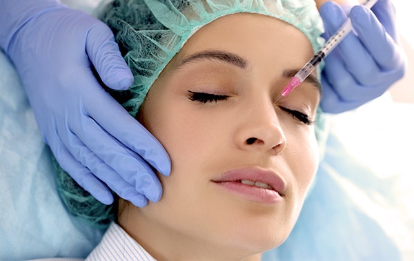 Woman receiving injection in nose