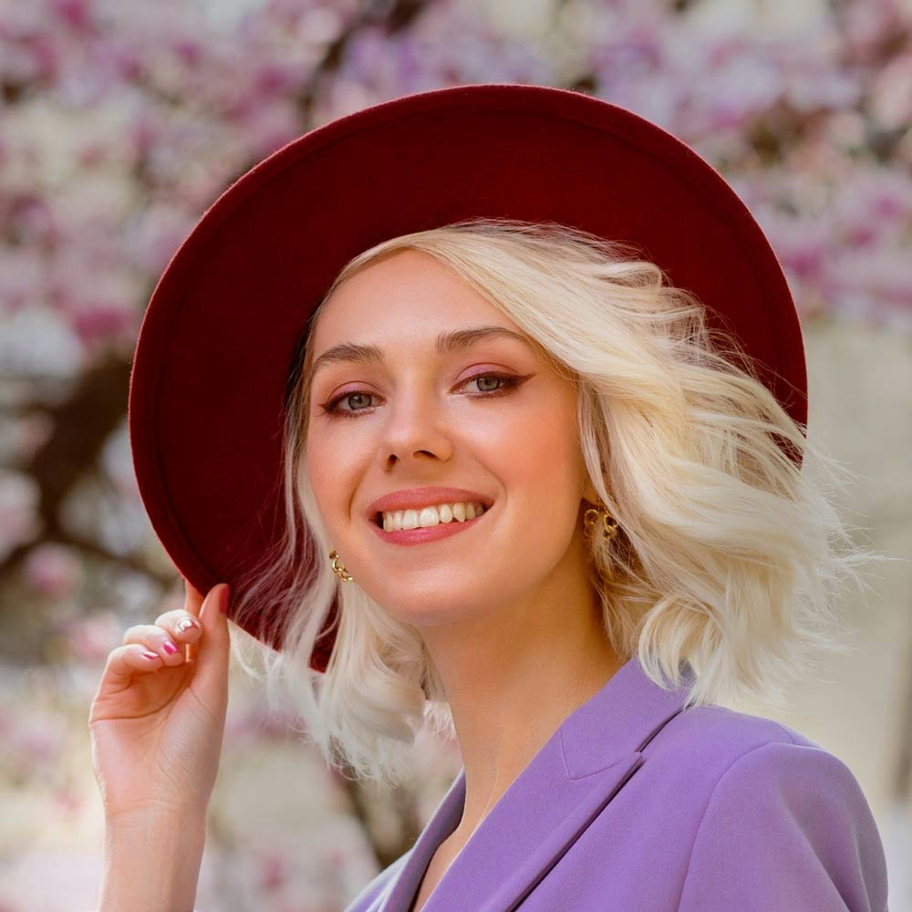 Smiling woman wearing a red hat with blepharoplasty
